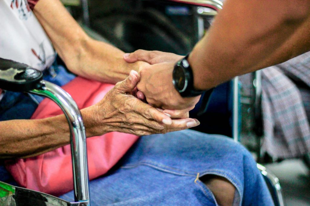 a young hand is holding an elderly woman hand Home Care and Hospice