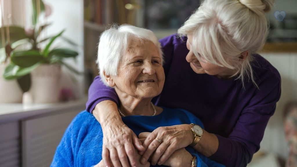 a elderly mother being hugged by her daughter
